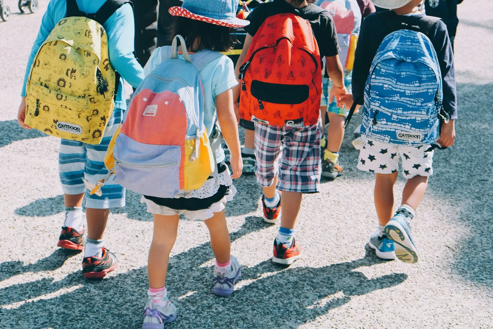 Kids walking to school wearing colorful backpacks