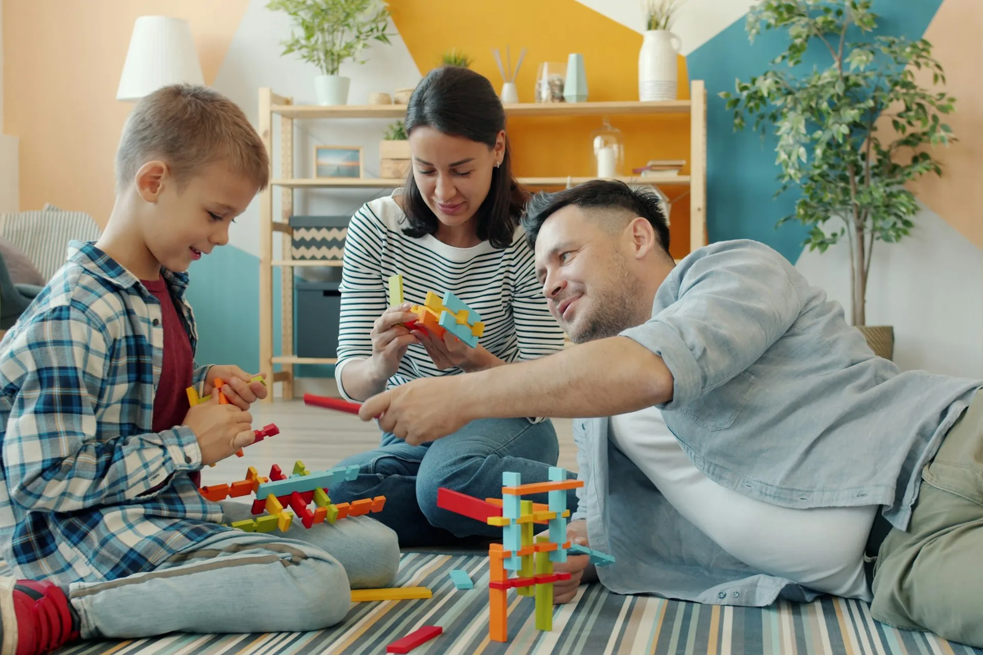 Family playing with building blocks together on the living room floor