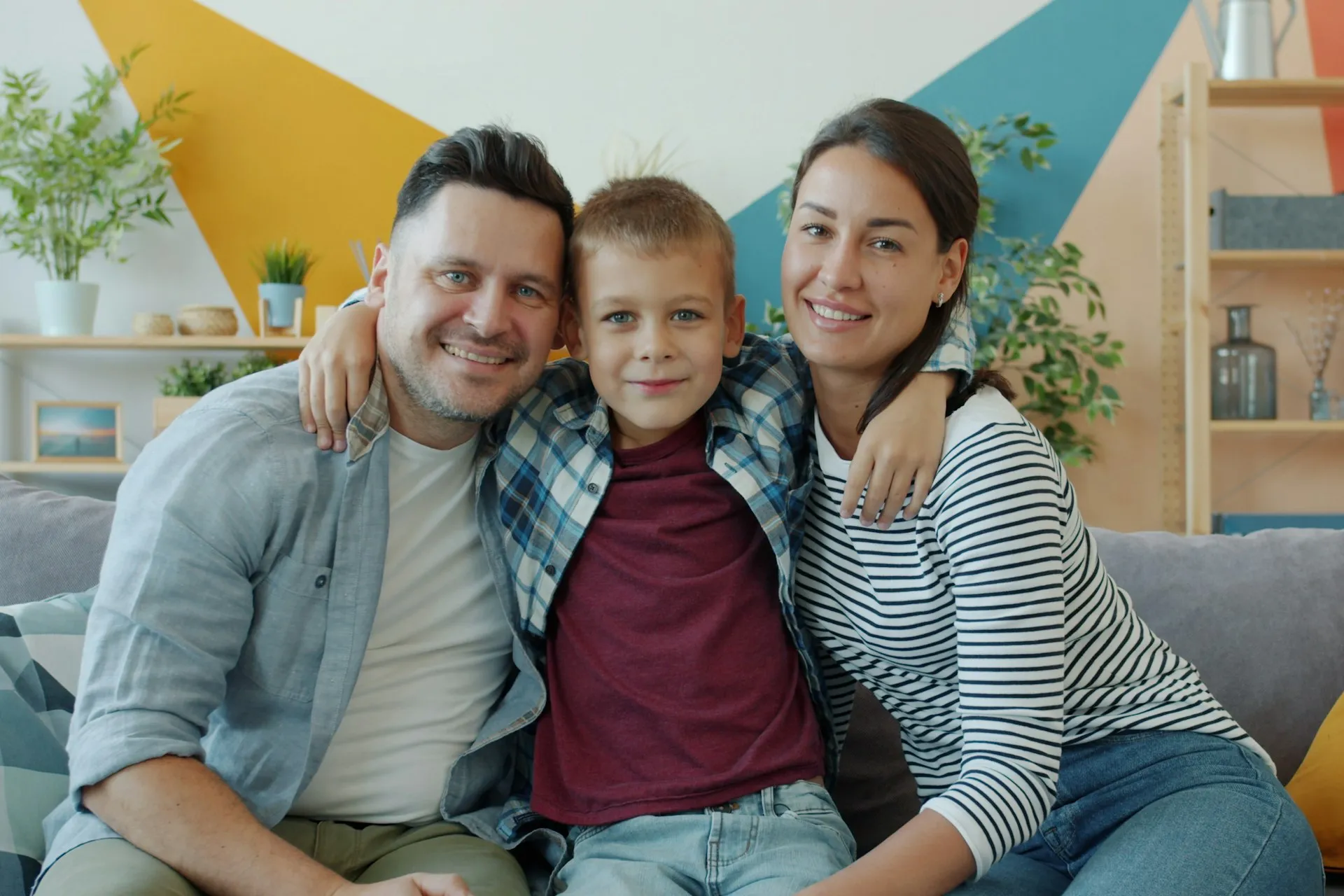 Parents and their son smiling together at home