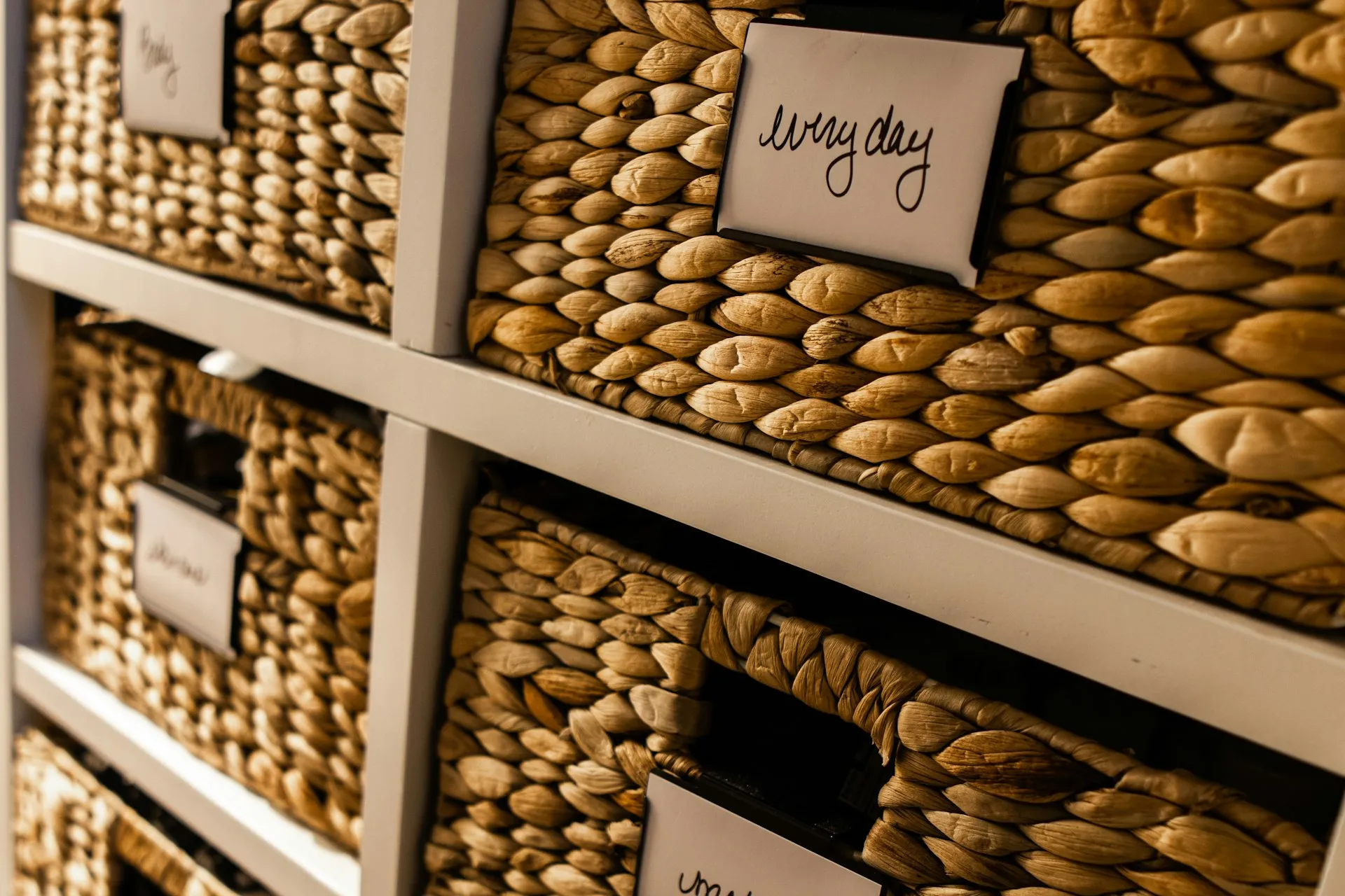 Neatly organized woven storage baskets with a handwritten "everyday" label